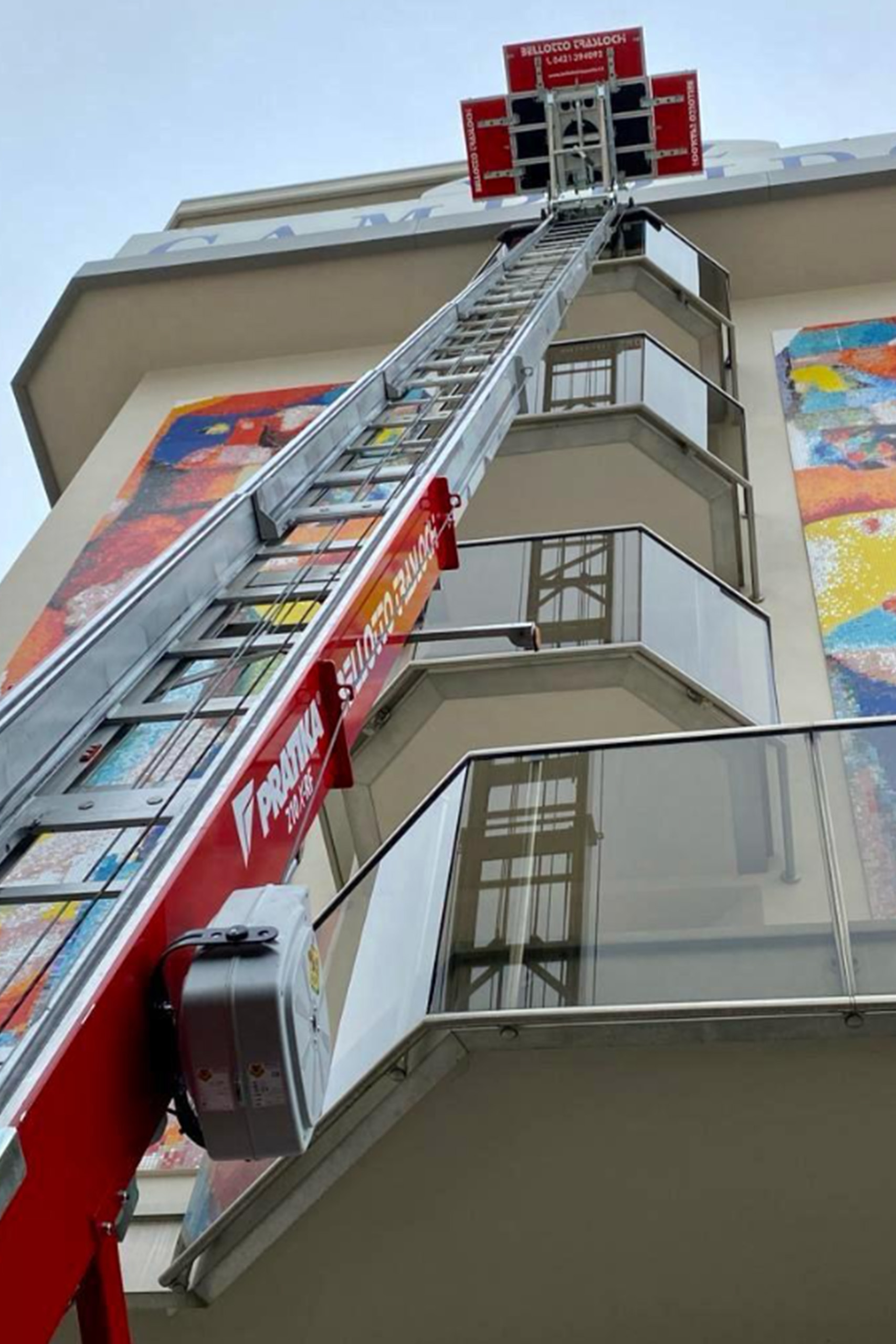 Autoscala sbracciata fino al quarto piano di un edificio con piattaforma in cima, servizio Bellotto Trasporti